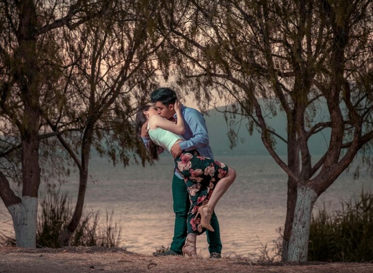 The Power of Everyday Romance: How Thoughtful Gestures Strengthen Relationships.couple kissing in front of trees