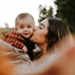 "Health and Love is a Powerful Force: How It Heals, Unites, and Transforms Lives"(woman kiss a baby while taking picture)
