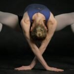 2030 and Beyond: How the Emotionally Strong Athlete Will Inspire Future Generations.(woman in blue sports bra and black panty bending her body)