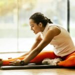 Transform Your Life with Love and Health: 25 Wellness Tips for a Vibrant Future(A woman enjoying a yoga stretch indoors, promoting a healthy lifestyle.)