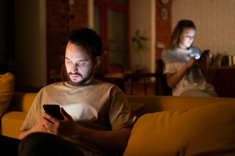 Digital Relationship Resilience: Building Stronger Bonds in the Connected World (Part 2) love,health, A couple enjoying a cozy evening in a warm home, both using smartphones.