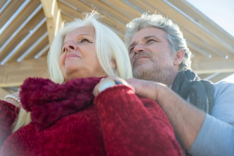 Love in the Age of Uncertainty: Navigating the Future. landscapes of love,(Loving senior couple embracing outdoors, under wooden structure in sunny Portugal.)