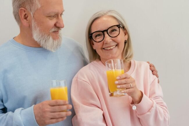 Love and Health Future 2025: Cultivating a Healthy Relationship with What's to Come. 2 Love and Health Future 2025: Cultivating a Healthy Relationship with What's to Come.(Smiling elderly couple holding glasses of fresh orange juice indoors.)