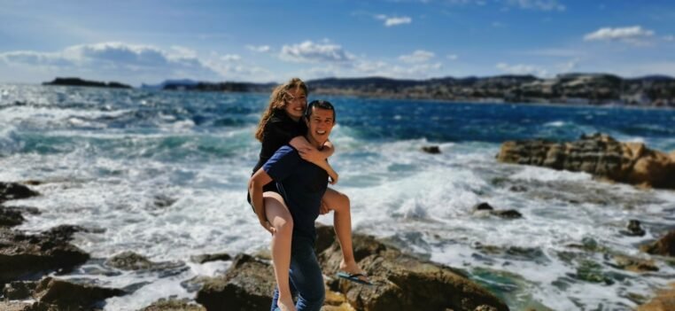 Balancing Love and Health in Australia.woman in blue tank top and blue denim shorts sitting on rock by the sea during