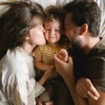 Love and health Part 3: Strengthening Love, Relationship, and Health in Canadian Life.A joyful family lying together on a bed, showcasing love and happiness.