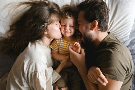 Love and health Part 3: Strengthening Love, Relationship, and Health in Canadian Life.A joyful family lying together on a bed, showcasing love and happiness.