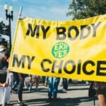 10 Health and Wellness Trends Defining 2026 3 10 Health and Wellness Trends Defining 2026. a group of people walking down a street holding a yellow sign