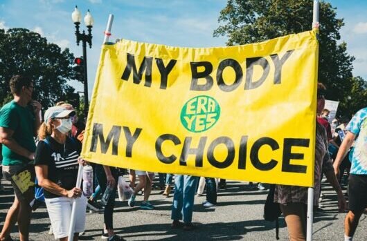 10 Health and Wellness Trends Defining 2026 1 10 Health and Wellness Trends Defining 2026. a group of people walking down a street holding a yellow sign